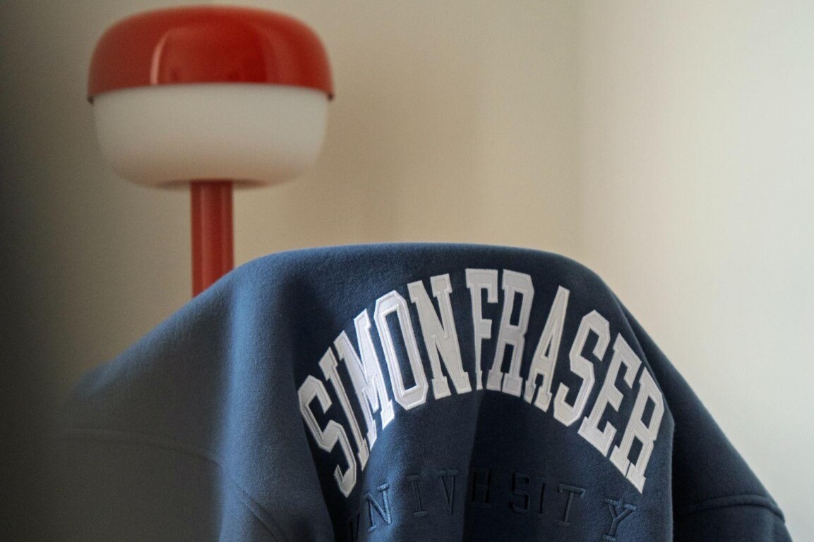 Simon Fraser University sweater draped over a chair.